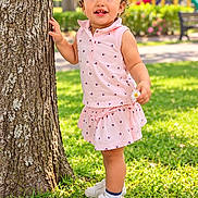 Aylanis is registered to the contest to win money with this photo: child, toddler, girl, smiling, curly_hair, hair_bow, pink_outfit, dress, flower, tree, park, playground, grass, outdoors, summer, portrait, standing, shoes, happy, sunlight