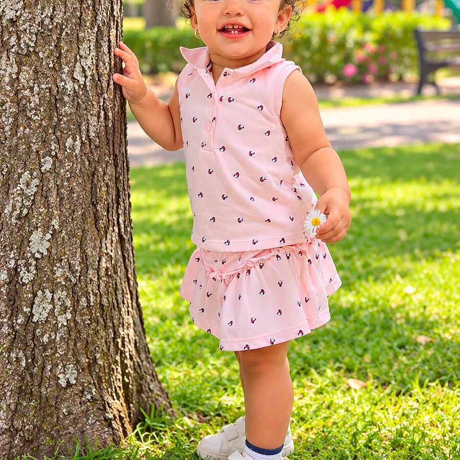 Aylanis is registered to the contest to win money with this photo: child, toddler, girl, smiling, curly_hair, hair_bow, pink_outfit, dress, flower, tree, park, playground, grass, outdoors, summer, portrait, standing, shoes, happy, sunlight
