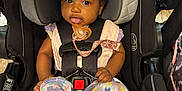 Brilani is registered to the contest to win money with this photo: baby, baby_clothes, baby_feet, black_car_seat, bow, car_seat, child, child_safety, closeup, colorful_clothing, cute, headband, indoor, infant, infant_fashion, pacifier, pink_fan, playful_expression, seatbelt, straps