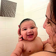 Mateo is registered to the contest to win money with this photo: baby, child, shower, water, smile, happy, person, adult, skin, face, hand, bathroom, tile, showerhead, wet, closeup, parent, love, together, care