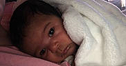 Kaia joined the competition — help win amazing prizes! baby, blanket, face, infant, cozy, soft, indoors, portrait, child, cute, sleepy, resting, pink, white, curtains, closeup, young, person, warm, comfort