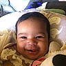 baby, smiling, face, infant, pillow, elephant_pattern, clothing, pacifier, stuffed_toy, closeup, cute, indoors, child, happy, soft_lighting, portrait, young_child, baby_girl, baby_boy, animal_print