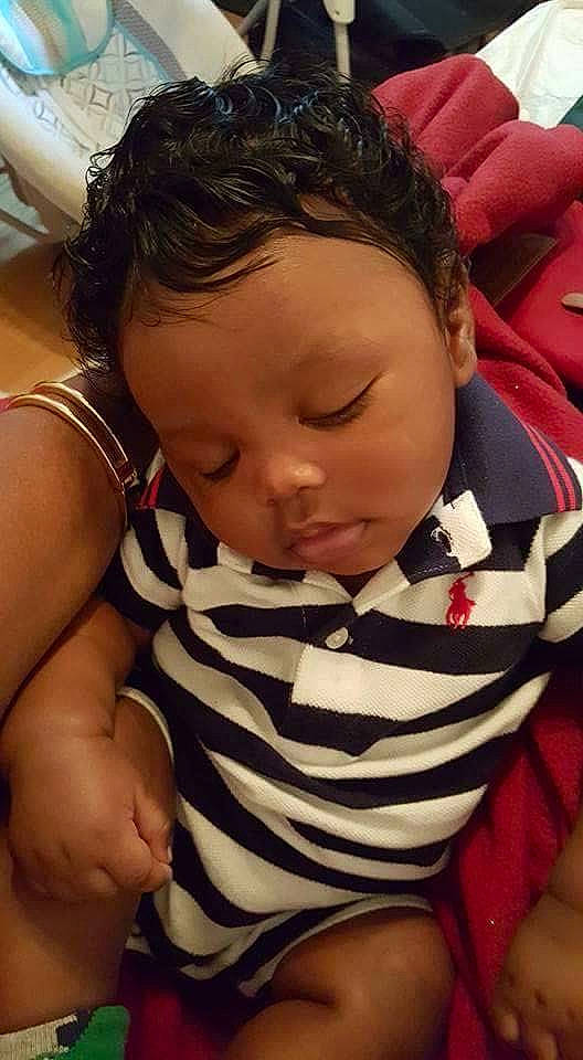 Davontae is registered to the contest to win money with this photo: arm, baby, black_hair, cheek, child, ear, face, finger, hand, head, mouth, nap, neck, nose, person, skin, sleep, toddler