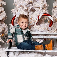 Kameron joined the competition — help win amazing prizes! child, toddler, bench, plaid_shirt, jeans, boots, christmas_tree, candy_cane, holiday, snow, decorations, smile, happy, indoor, seasonal, festive, white, green, red, portrait