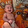 baby, diaper, smiling, laughing, infant, orange_blanket, pumpkin, autumn, fall_decor, pillows, flowers, wooden_crate, cozy, indoors, cute, child, happy, celebration, seasonal, festive