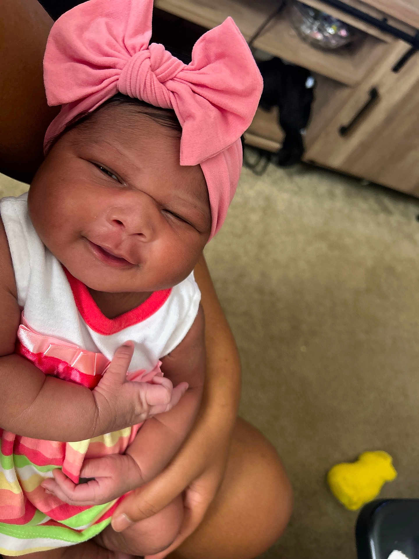 Kehlani joined the competition — help win amazing prizes! baby, infant, pink_bow, headband, smile, cute, child, striped_dress, arms, holding, person, indoor, carpet, furniture, drawer, yellow_toy, skin, happy, portrait, closeup