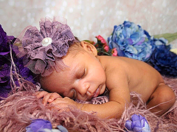 Amelia is registered to the contest to win money with this photo: baby, bedtime, blue, child, doll, eye, fashion_accessory, grass, hair_accessory, happy, headband, headpiece, iris, jewellery, linens, people_in_nature, person, purple, sitting, textile