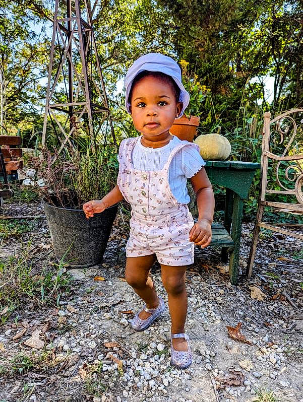 Zariyah joined the competition — help win amazing prizes! baby_toddler_clothing, electric_blue, face, fun, garden, grass, happy, hat, head, leisure, people_in_nature, person, plant, recreation, sandal, shorts, sitting, soil, t_shirt, toddler
