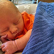 Noah joined the competition — help win amazing prizes! baby, newborn, sleeping, blanket, orange_clothing, hand, face, peaceful, resting, infant, cute, skin, closeup, portrait, cozy, soft, indoors, star_pattern, pillow, child