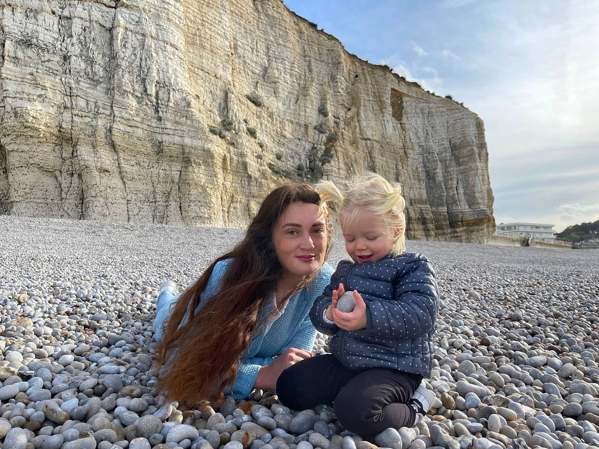 Eleonora a rejoint le concours — aidez-le/la à gagner de superbes lots ! azure, beach, bedrock, body_of_water, child, cloud, face, fun, geology, happy, joy, landscape, leisure, people_in_nature, person, rock, sitting, sky, toddler, travel