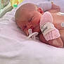newborn, baby, hospital, incubator, medical_tubes, pink_mitten, white_bedding, yellow_towel, resting, infant, patient, healthcare, sleeping, closeup, delicate, tiny, child, person, neonatal_care, hospital_room