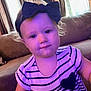 toddler, child, indoor, striped_dress, headband, couch, curtains, window, face, person, young_child, purple_tint, smile, hair, baby, clothing, furniture, portrait, sitting, cute