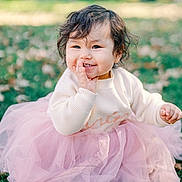 Leah is registered to the contest to win money with this photo: toddler, child, smiling, curly_hair, pink_tutu, cream_sweater, grass, autumn_leaves, outdoor, nature, cute, happy, baby, portrait, sitting, playful, daylight, soft_light, fall, young_child