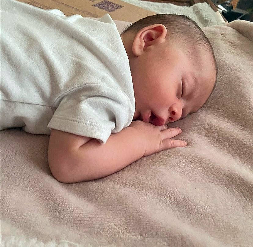 Declan is registered to the contest to win money with this photo: baby, baby_sleeping, baby_toddler_clothing, bed_sheet, bedding, bedtime, blanket, child, comfort, flooring, hand, linens, nap, pattern, person, portrait_photography, room, skin, sleeve, toddler