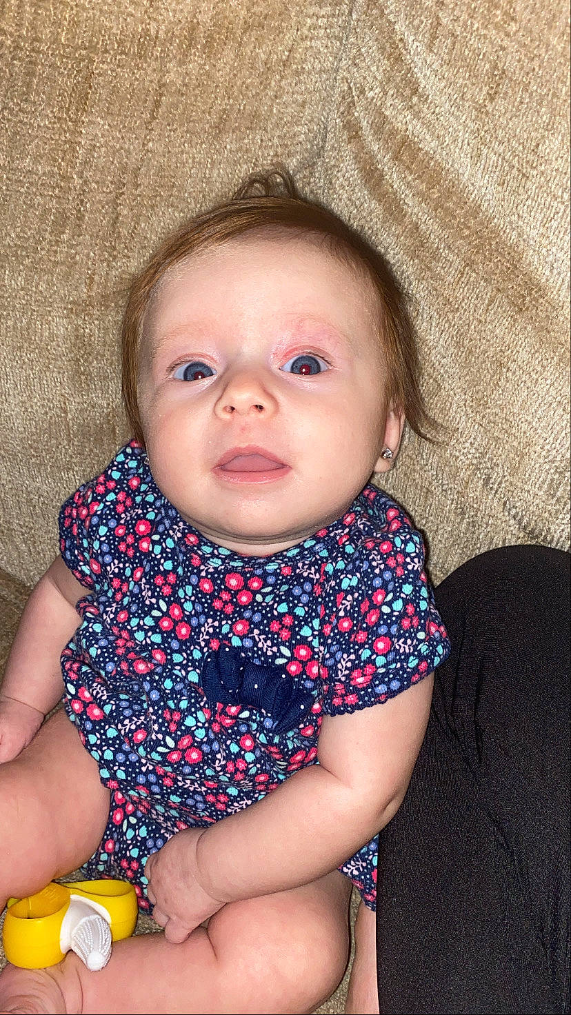 Ana is registered to the contest to win money with this photo: baby, cheek, child, eye, face, head, iris, lip, mouth, neck, nose, person, sitting, skin, smile, toddler