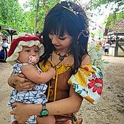 Gardenia joined the competition — help win amazing prizes! baby, child, woman, holding, pacifier, hat, costume, festival, outdoor, greenery, trees, people, necklace, bracelet, smile, flower_pattern, face, portrait, clothing, hand