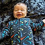baby, blanket, bodypart, clothing, coat, face, finger, hand, happy, head, hoodie, jacket, knitwear, person, photography, portrait, quilt, smile, sweater, sweatshirt
