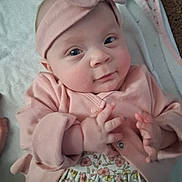 Delilah is registered to the contest to win money with this photo: adorable, baby, blanket, child, cozy, cute, expression, eyes, face, floral_dress, hand, headband, indoor, infant, lying_down, pink_clothing, portrait, skin, small_fingers, soft_texture