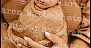 Bentley is registered to the contest to win money with this photo: newborn, baby, swaddled, sleeping, hand, person, portrait, soft_lighting, warm_tones, blanket, clothing, nail_polish, ring, closeup, indoor, cozy, gentle, peaceful, photography, watermark