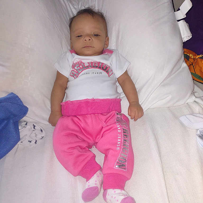 Aveiona joined the competition — help win amazing prizes! baby, infant, bed, pillow, clothing, pink_pants, white_shirt, socks, face, person, lying_down, blanket, fabric, indoors, child, newborn, portrait, cute, resting, soft