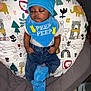baby, sleeping, blue_hat, blue_bib, blue_slippers, denim_pants, animal_pattern, cushion, infant, cute, peaceful, indoors, child, soft_toys, plush_slippers, face, hands, footwear, clothing, resting