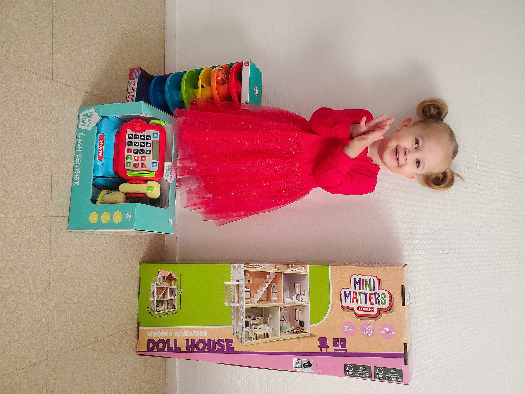 Arina participe au concours pour gagner de l'argent avec cette photo : baby_products, baby_toddler_clothing, child, dress, font, happy, joy, magenta, peach, person, pink, plastic, play, room, shelf, shelving, sleeve, sock, toddler, toy