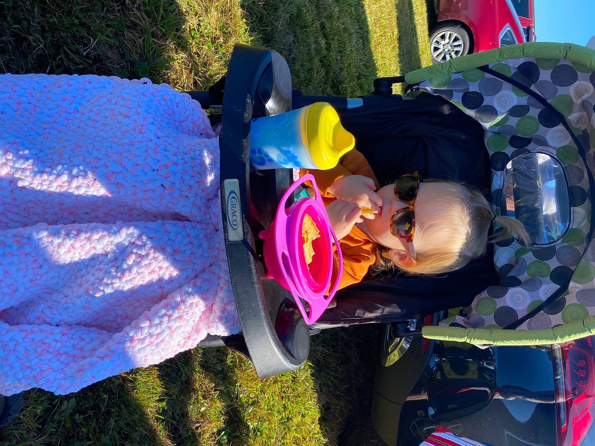 Lacey is registered to the contest to win money with this photo: auto_part, automotive_tire, automotive_wheel_system, child, electric_blue, event, fun, grass, hat, headgear, leisure, magenta, person, plant, recreation, tints_and_shades, tire, toddler, tree, wheel