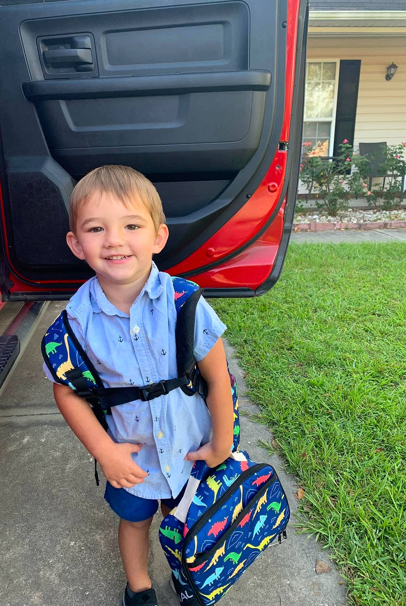 Leon is registered to the contest to win money with this photo: automotive_design, automotive_exterior, automotive_lighting, automotive_tire, blue, bumper, electric_blue, fun, gas, grass, joy, light, motor_vehicle, person, plant, red, smile, toddler, vehicle, vehicle_door