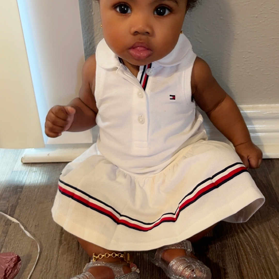 Acelynn is registered to the contest to win money with this photo: toddler, child, girl, dress, white_dress, hair_bows, red_bows, silver_shoes, ankle_bracelet, floor, wooden_floor, indoor, curious_expression, sitting, cute, fashion, portrait, person, young_child, innocence