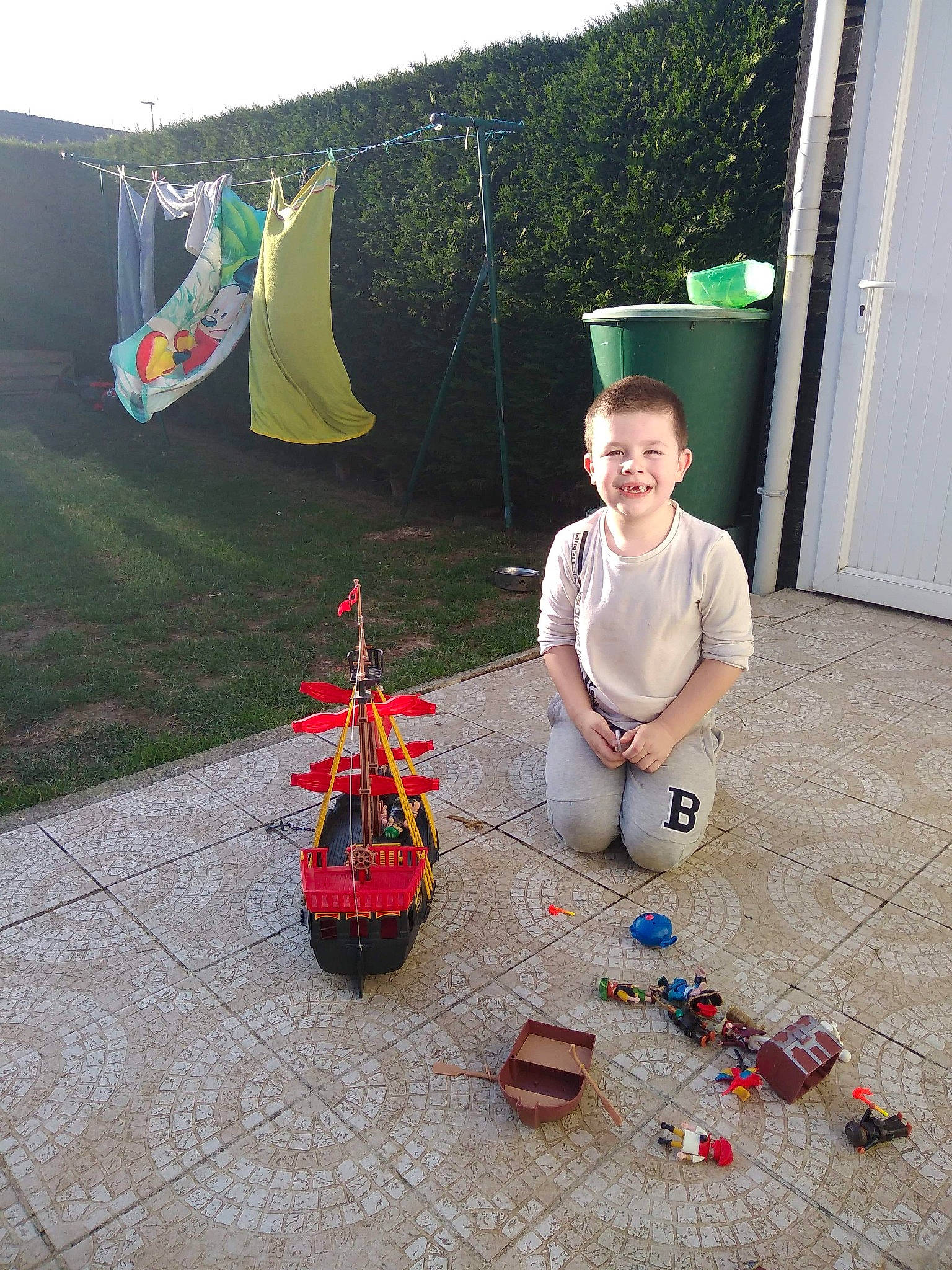 Mayron participe au concours pour gagner de l'argent avec cette photo : cone, door, event, flooring, fun, grass, green, joy, leisure, musical_instrument, person, plant, pole, recreation, shade, sitting, sky, smile, tent, toy