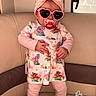 baby, toddler, heart_sunglasses, pacifier, headband, pink_bow, animal_print, dress, leggings, shoes, couch, teddy_bear, indoor, child, cute, standing, accessories, playful, furniture, doodle