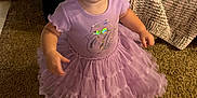 Evelyn joined the competition — help win amazing prizes! toddler, child, purple_dress, carpet, indoor, person, footwear, blanket, furniture, curious, standing, soft_lighting, home, baby, cute, clothing, floor, texture, portrait, young_child