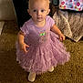 toddler, child, purple_dress, carpet, indoor, person, footwear, blanket, furniture, curious, standing, soft_lighting, home, baby, cute, clothing, floor, texture, portrait, young_child