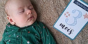 Noah a rejoint le concours — aidez-le/la à gagner de superbes lots ! baby, sleeping, infant, shirt, green, milestone_card, text, blanket, fabric, closeup, face, child, cute, peaceful, portrait, indoors, soft, cozy, rest, young