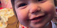 Athena is registered to the contest to win money with this photo: child, toddler, smiling, face, close_up, strawberry_pattern, shirt, indoor, wooden_floor, happy, cute, person, baby, expression, young_child, portrait, playful, clothing, cheerful, infant