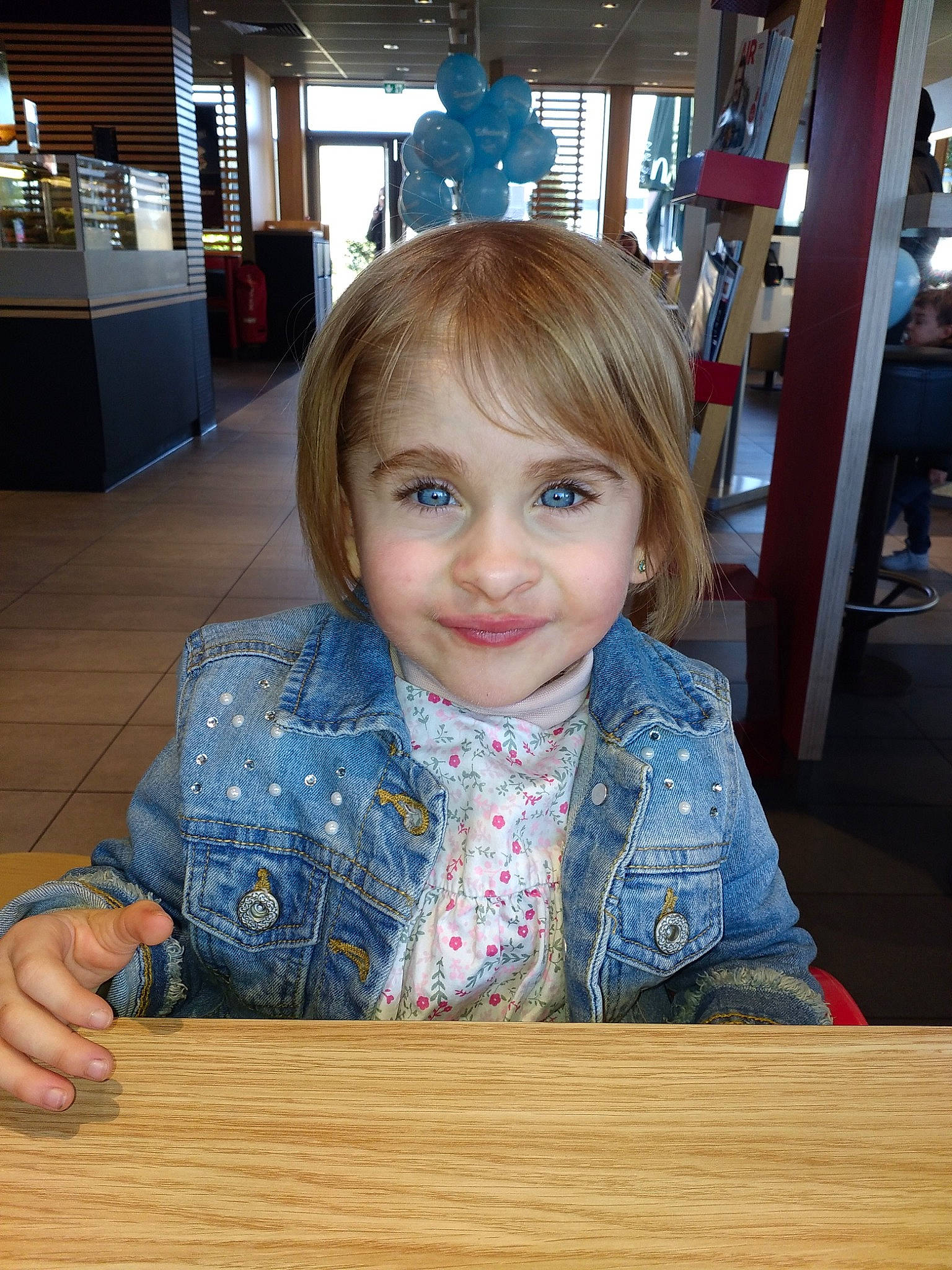 Lana a rejoint le concours — aidez-le/la à gagner de superbes lots ! blond, child, floor, flooring, fun, hair, iris, person, sitting, smile, table, toddler, vacation, wood