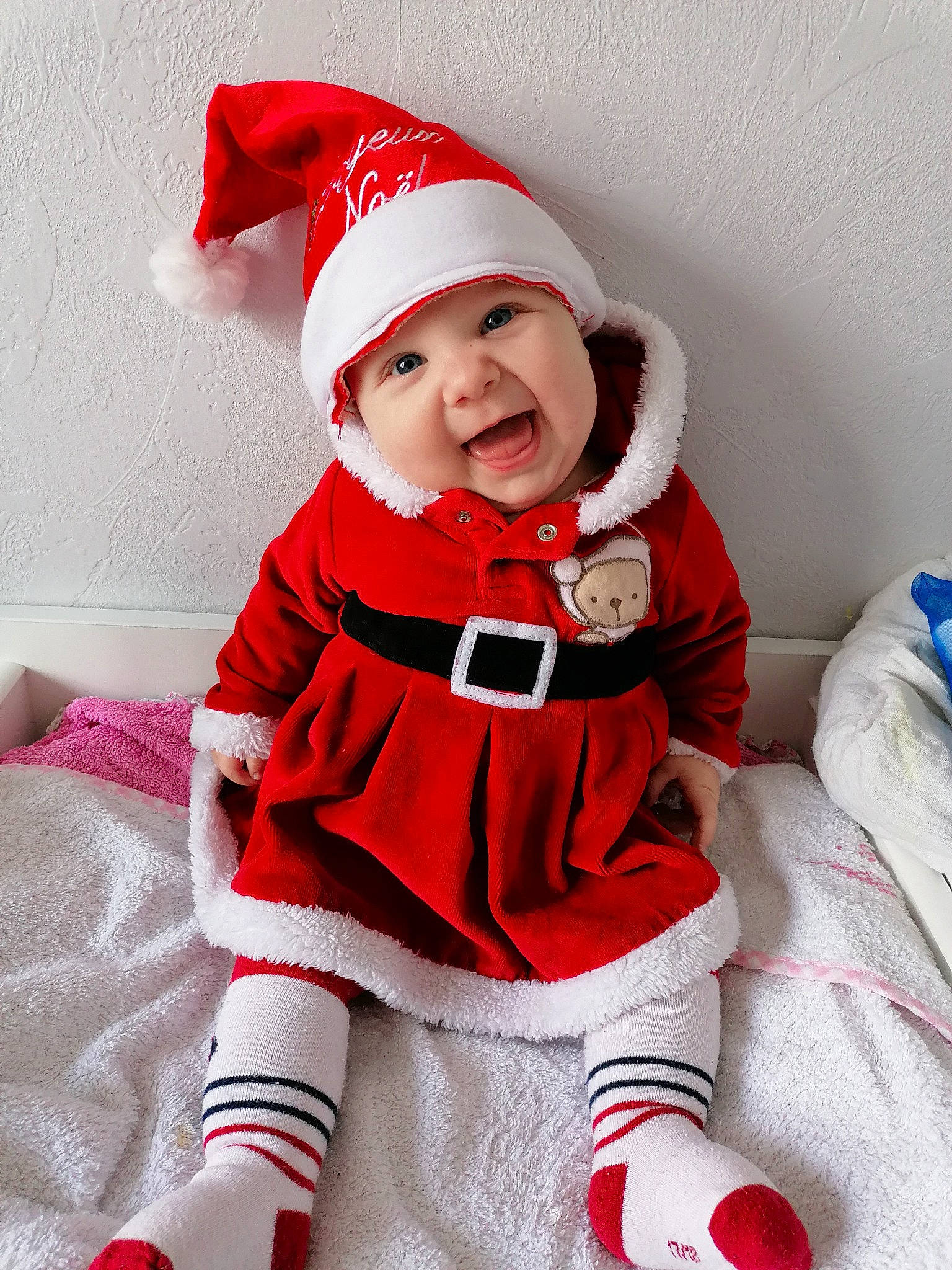 Mia a rejoint le concours — aidez-le/la à gagner de superbes lots ! arm, baby, baby_toddler_clothing, cap, collar, costume_hat, event, face, fictional_character, hat, head, headwear, human_body, jacket, lap, person, santa_claus, sleeve, smile, sock