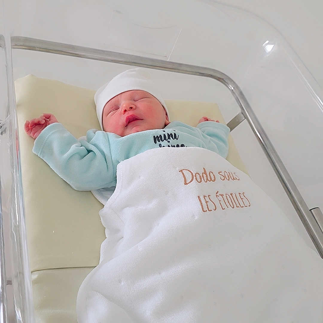 Rayed a rejoint le concours — aidez-le/la à gagner de superbes lots ! newborn, baby, sleeping, hospital, bassinet, blanket, hat, infant, bed, rest, peaceful, child, clothing, white, blue, portrait, indoors, healthcare, soft, cute