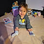 Kassim participe au concours pour gagner de l'argent avec cette photo : toddler, child, smiling, sitting, indoor, toy, socks, clothing, face, happy, playful, cute, baby, soft_surface, sweatshirt, room, colorful, person, young, fun