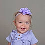 baby, child, girl, headband, flower, smile, portrait, clothing, purple, ruffles, cute, happy, face, infant, young_child, studio, neutral_background, headwear, fashion, toddler
