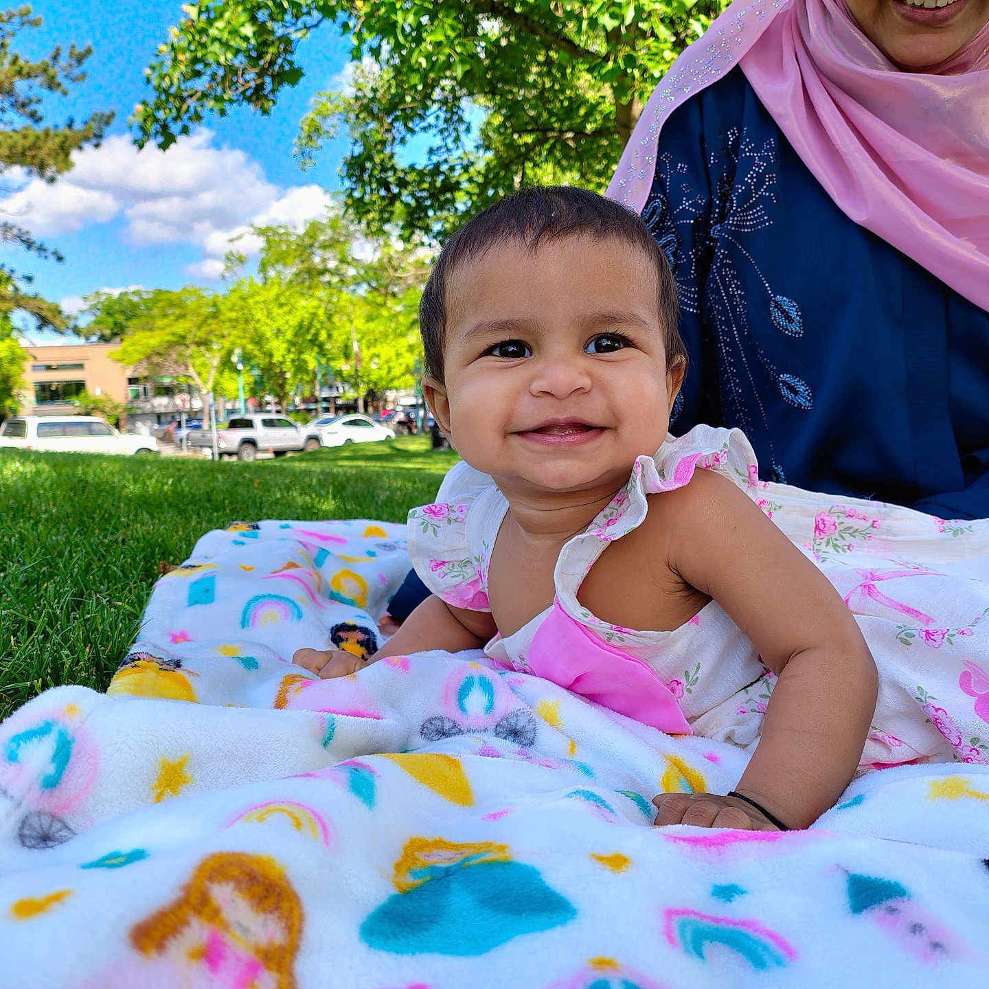 Zainab Saleha is registered to the contest to win money with this photo: baby, child, smile, blanket, grass, outdoor, park, person, woman, scarf, blue_clothing, pink_scarf, sunny, daylight, nature, trees, happy, cute, infant, portrait