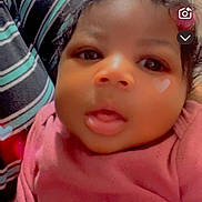 Demariya joined the competition — help win amazing prizes! baby, infant, face, closeup, pink_clothing, heart_shape, curly_hair, striped_fabric, indoors, portrait, child, cute, expression, person, skin, head, young, app_icons, digital_overlay, soft_lighting