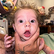 Ezrah joined the competition — help win amazing prizes! baby, blurred_background, child, expression, face, fingers, furniture, hair, hand, holding, human, indoor, mouth_open, person, room, skin, spider_tattoo, surprised_expression, tattoo, wide_eyes
