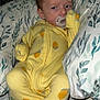 Ezrah is registered to the contest to win money with this photo: baby, bed, bedding, blanket, child, cozy, cute, expression, face, footed_pajamas, indoors, infant, lemon_pattern, pacifier, person, pillow, resting, sleepwear, yellow_onesie, young