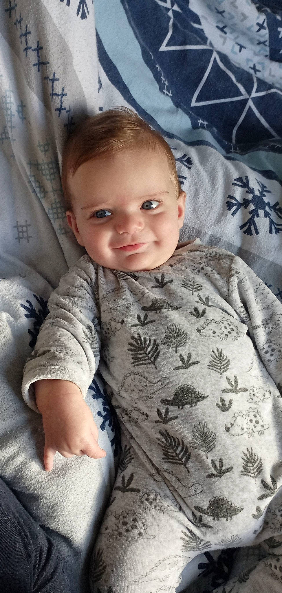 William participe au concours pour gagner de l'argent avec cette photo : baby, baby_toddler_clothing, bedding, cheek, child, comfort, elbow, eye, fun, head, joy, linens, pattern, person, room, sitting, skin, sleeve, smile, t_shirt