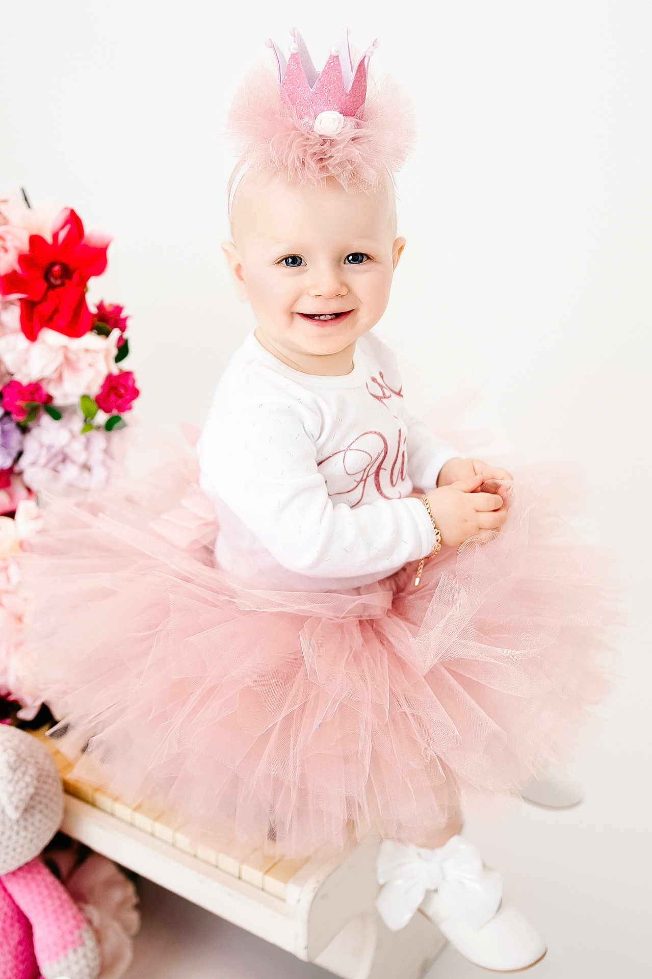 Alice participe au concours pour gagner de l'argent avec cette photo : toddler, child, baby, pink_tutu, crown_headband, smiling, sitting, white_piano, flowers, indoor, cute, dress, footwear, bracelet, happy, portrait, blonde_hair, bright, soft_lighting, celebration