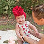 baby, blanket, cake, casual_clothing, child, grass, happy, headband, holding, nature, outdoor, person, picnic, portrait, red_flower, smiling, strawberries, strawberry_pattern, summer, woman