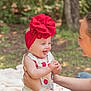 adult, baby, blanket, child, cute, family, giggle, grass, happy, headband, holding, nature, outdoor, person, playful, portrait, red_bow, smile, strawberry_pattern, summer