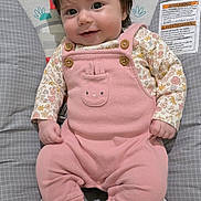 Mia joined the competition — help win amazing prizes! baby, infant, smiling, pink_onesie, hair_clip, flower, baby_seat, cushion, patterned, socks, cute, child, portrait, indoor, happy, small_hands, dark_hair, button, fabric, face