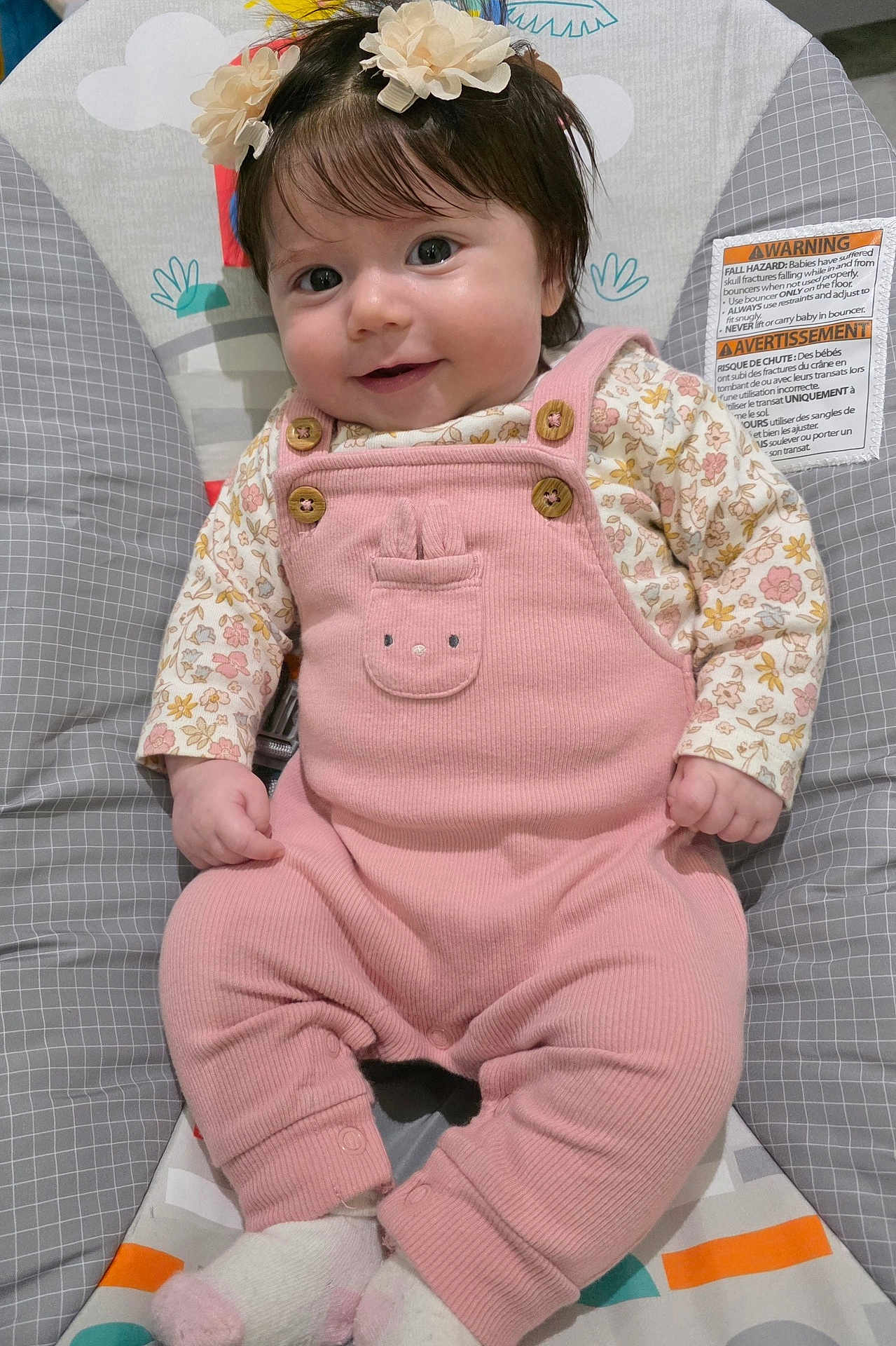 Mia joined the competition — help win amazing prizes! baby, infant, smiling, pink_onesie, hair_clip, flower, baby_seat, cushion, patterned, socks, cute, child, portrait, indoor, happy, small_hands, dark_hair, button, fabric, face